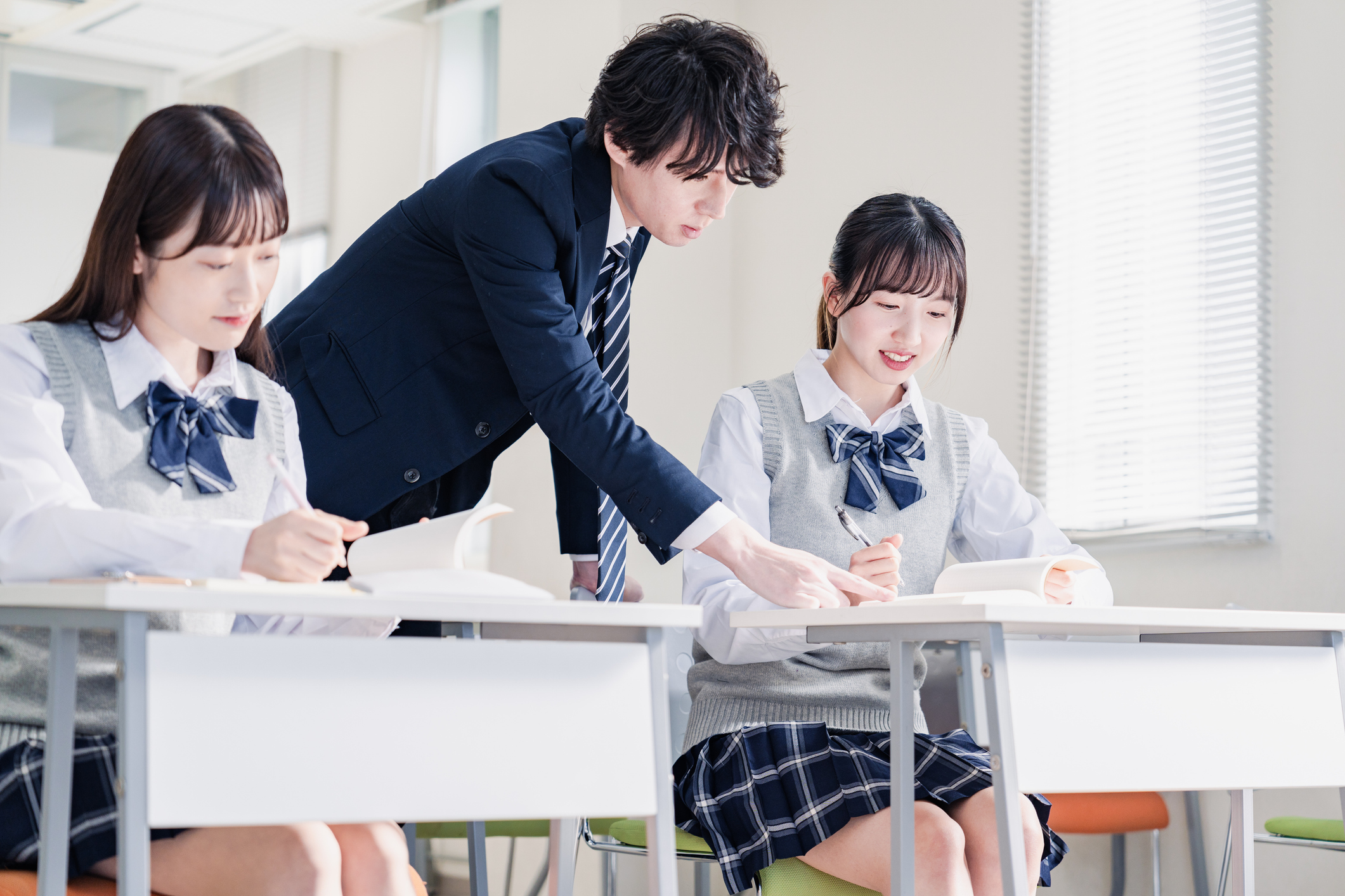 High school student asking a question to her teacher in the classroom