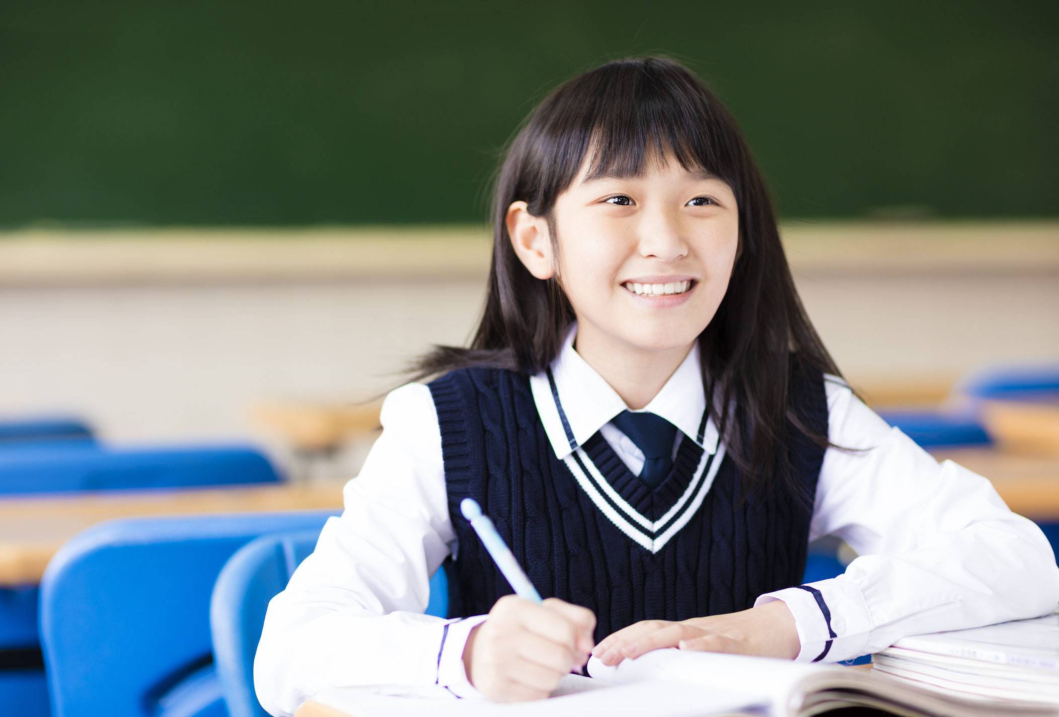 happy pretty  student girl with books in classroom